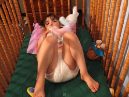 Little girl wearing diaper asleep in crib