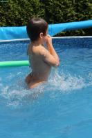 Cute boy in pool and garden